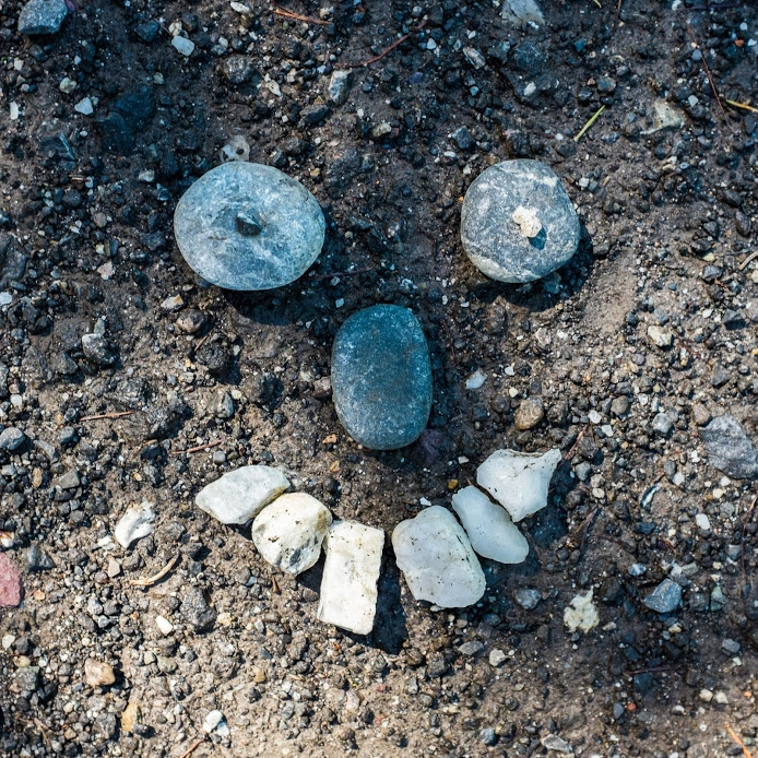 stones-arranged-as-a-face-on-the-ground.webp