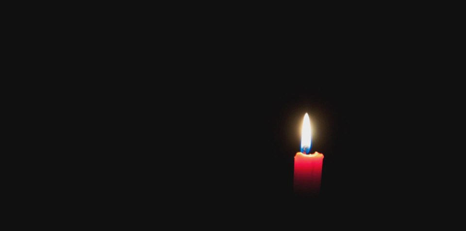 lit-candle-in-a-black-room.webp