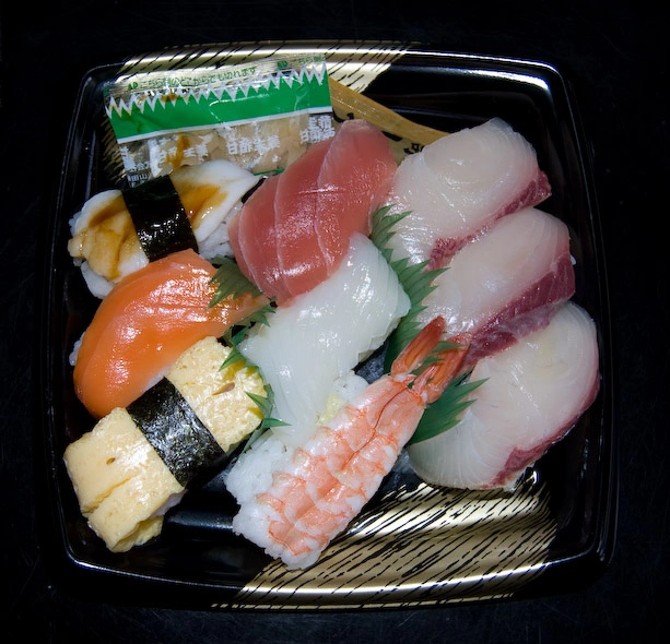 Otro ejemplo de bento, este especializado en pescado. Cada envoltorio de pescado está envuelto de arroz.