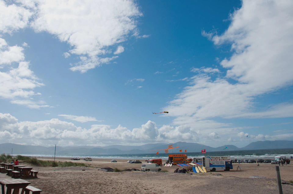 Kites, sun, a gorgeous sky, a beach and Irish people surfing.