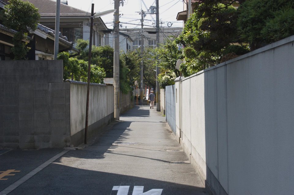 kita-tatsumi-narrow-road-between-walls.webp