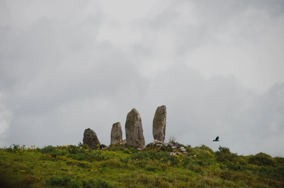 Four neolithic stones defying gravity like tossed coins landing on their edges.