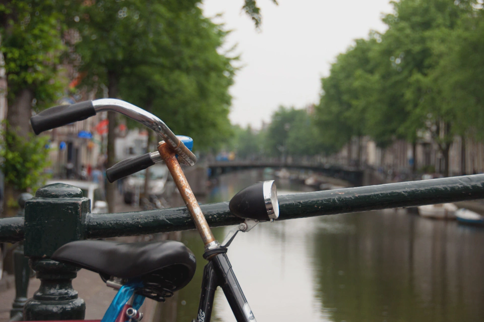 close-up-rusty-bike-hand-rail-against-amsterdam-canal-bridge.webp